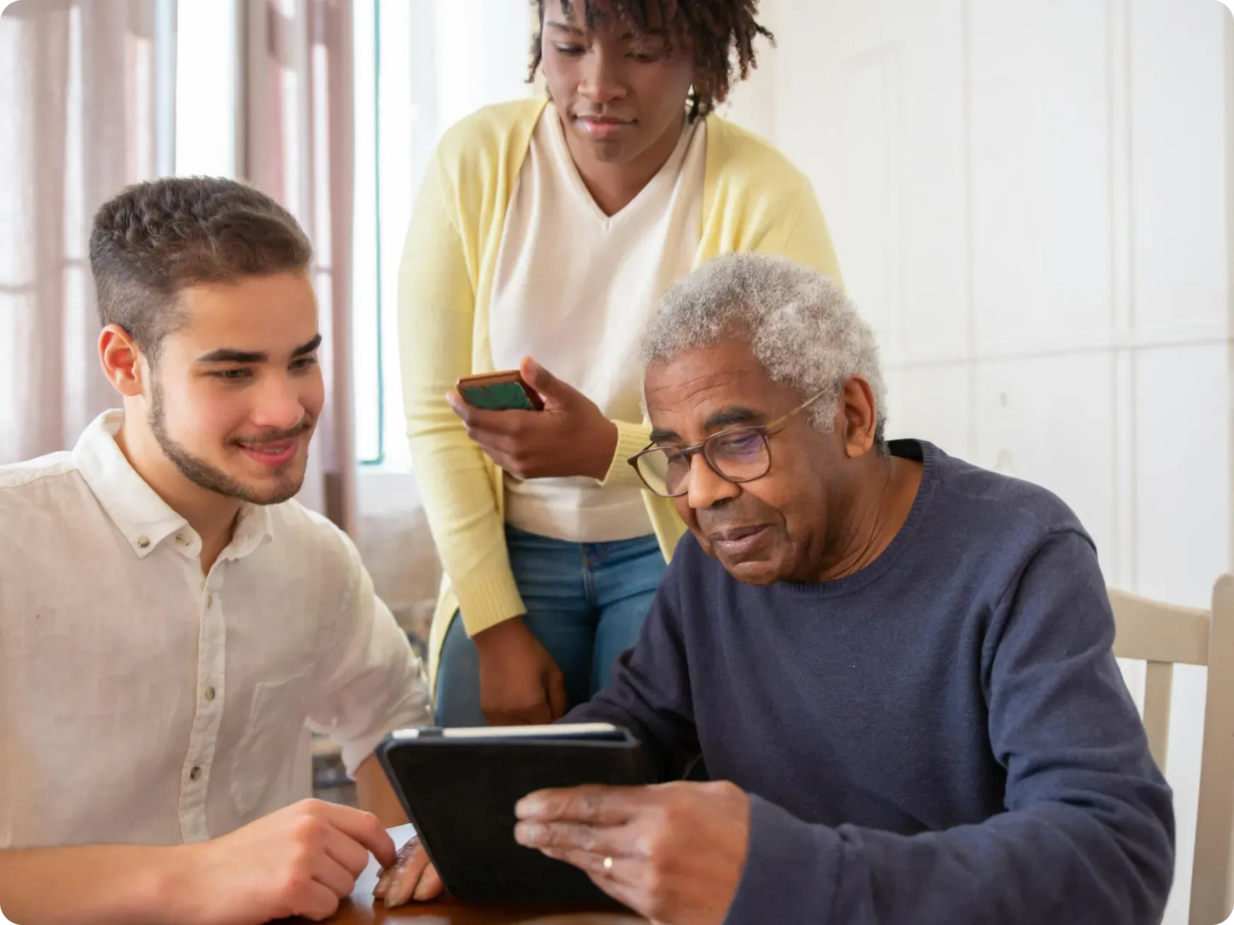 Elderly Man and Carers Looking at Laptop [content]