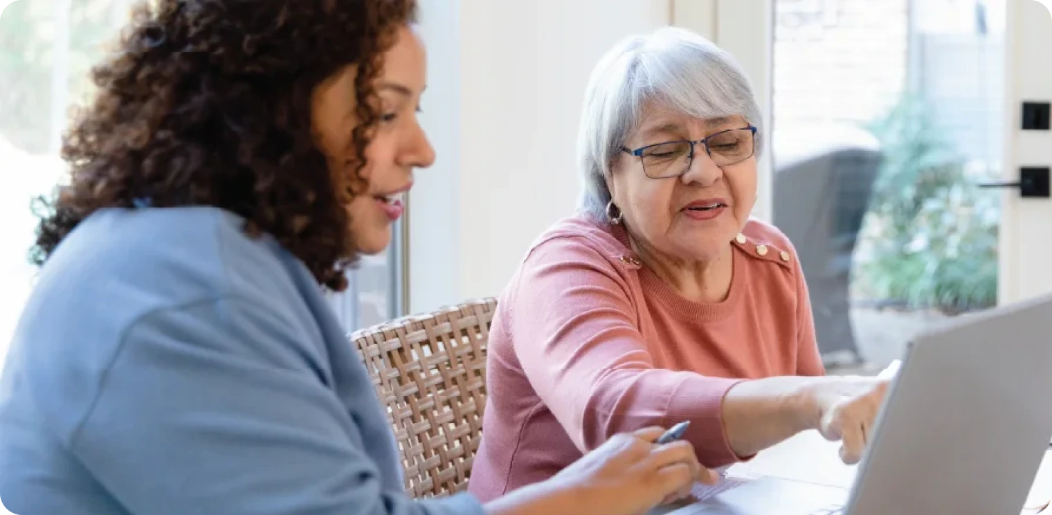 Elderly Woman Pointing at Laptop [header]